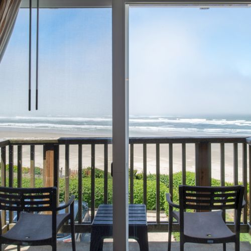 A balcony view with a railing, sliding glass doors, and a sunny outdoor scene beyond. Top it at 140 characters, always ending the sentence.